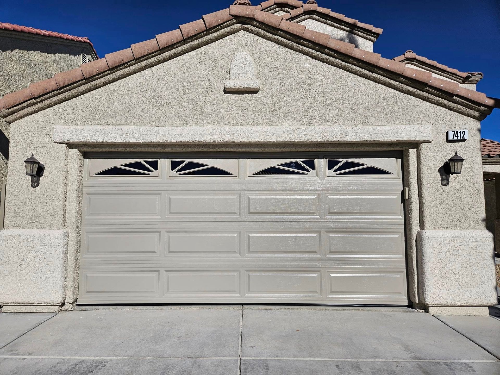 A garage door is open in front of a house.