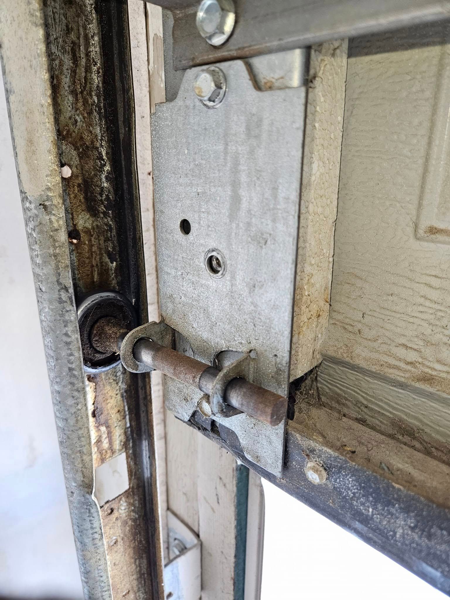 A close up of a garage door with a screw in it.