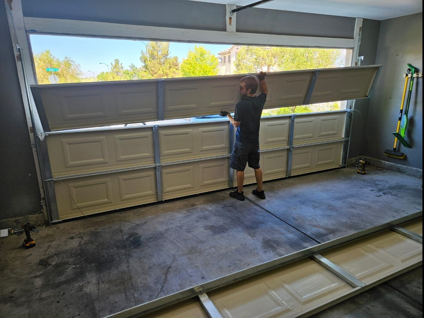 A man is opening a garage door in a garage.