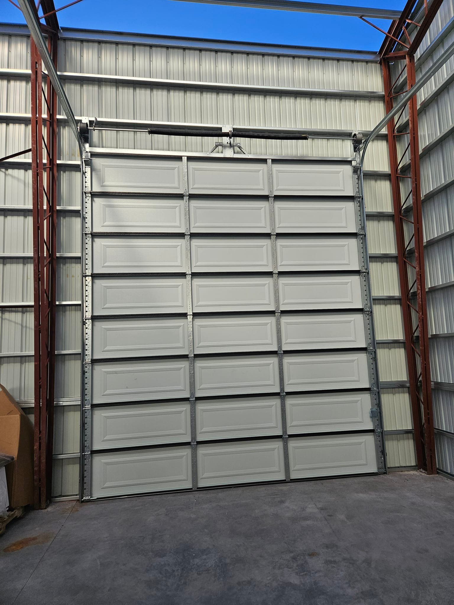 A large white garage door is open in a building.