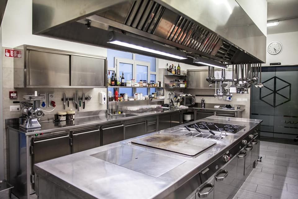 una cucina con elettrodomestici in acciaio inossidabile e un orologio a parete