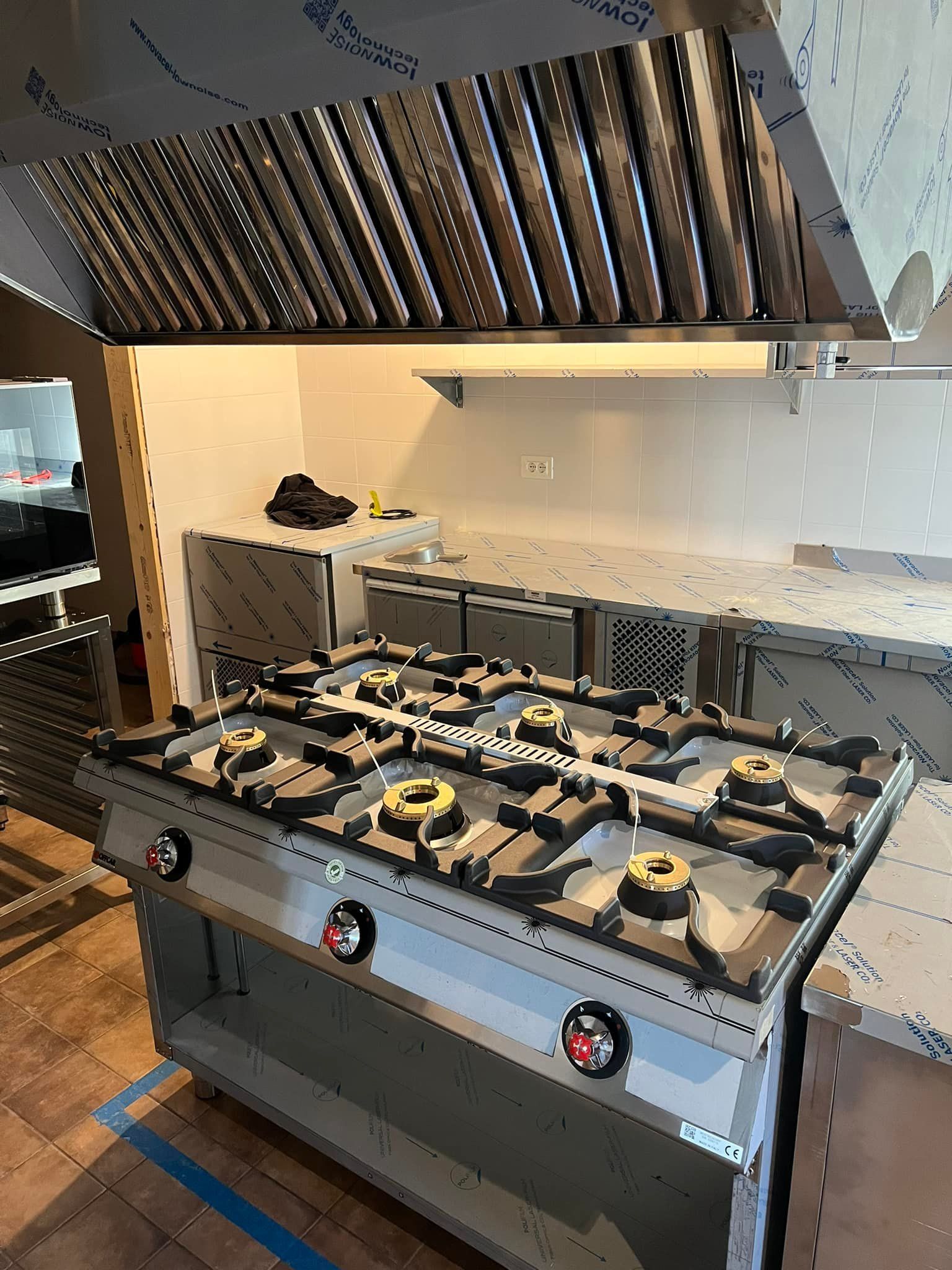 un piano cottura in acciaio inossidabile con una cappa su cui è scritto un foglio di alluminio