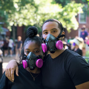 Two people wearing black respirators fit testing