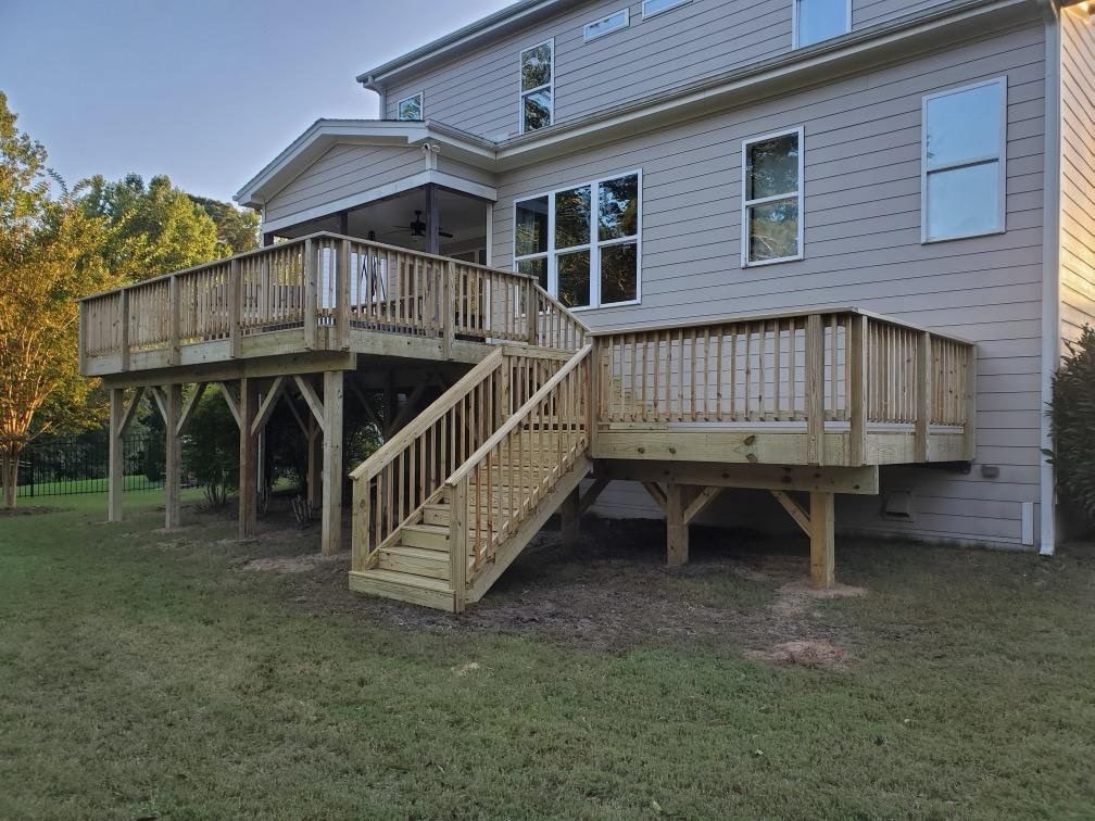 Newly framed two-story deck on a large home at golden hour