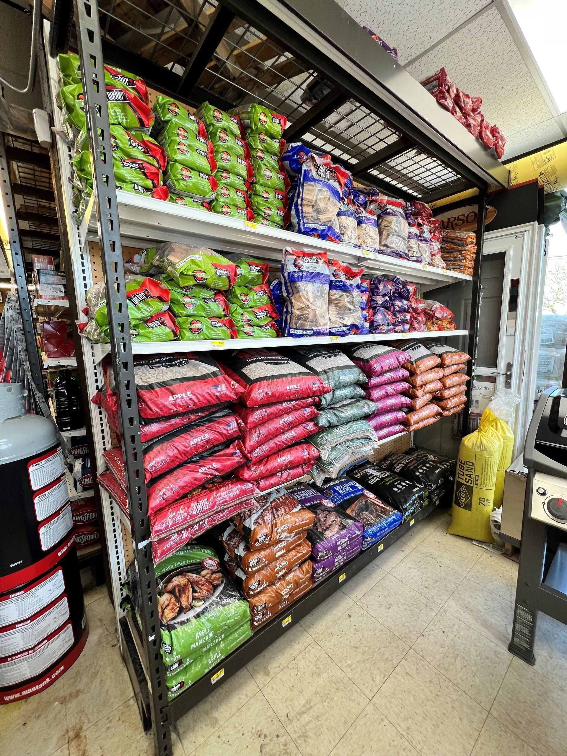 Shelves stacked with bagged pet food of various colors and brands in a store.