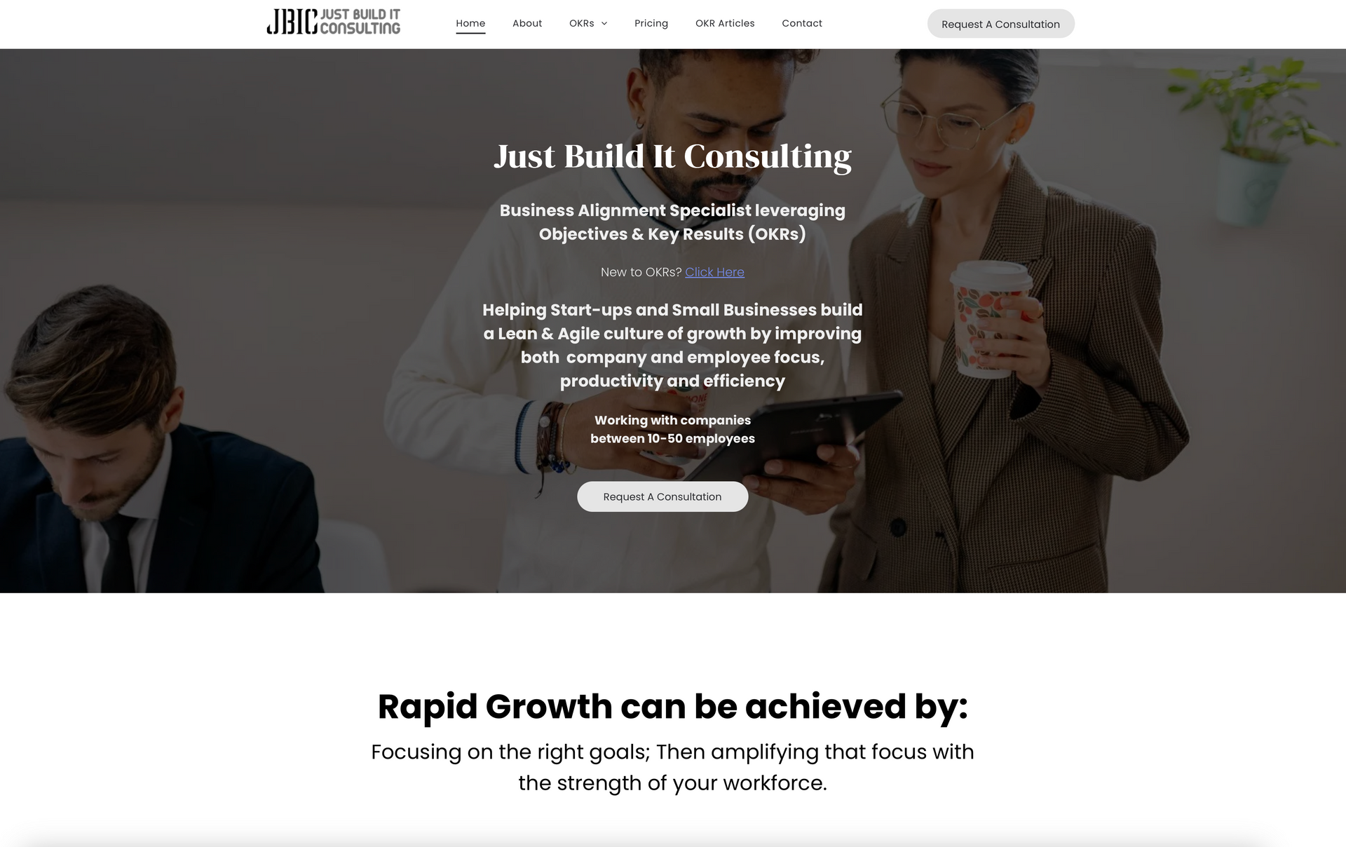 a man and a woman are standing next to each other looking at a tablet .