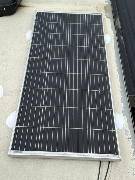 A black and white solar panel is sitting on a roof