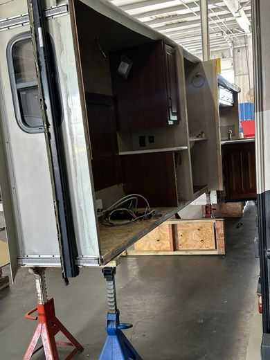 A trailer is being built in a garage with the door open.