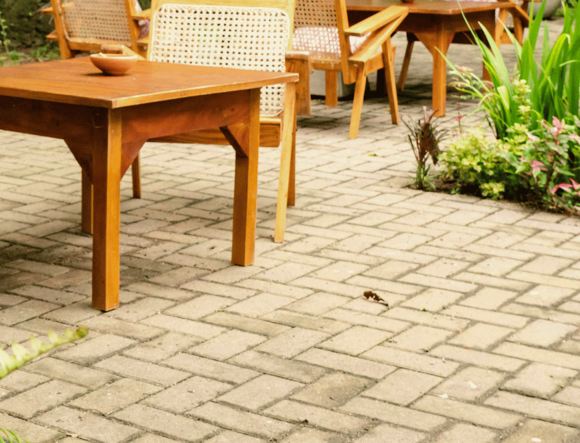An image of a worker pouring asphalt on the cracked concrete driveway.