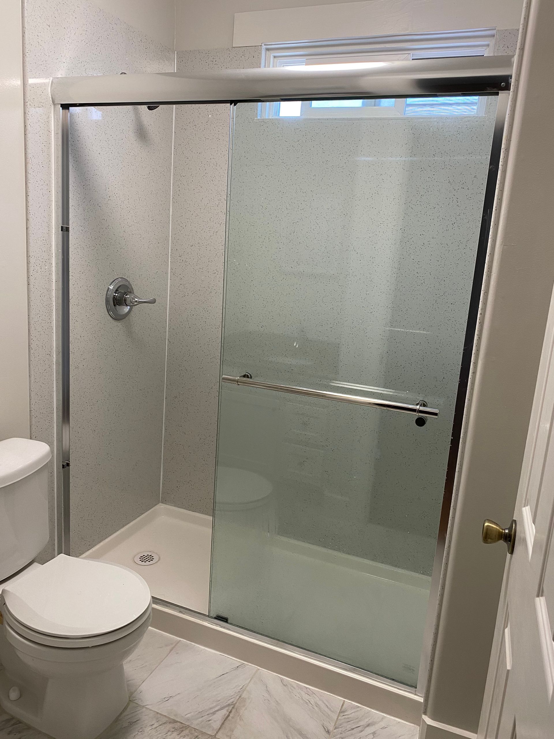 A bathroom with a toilet , shower and bathtub.