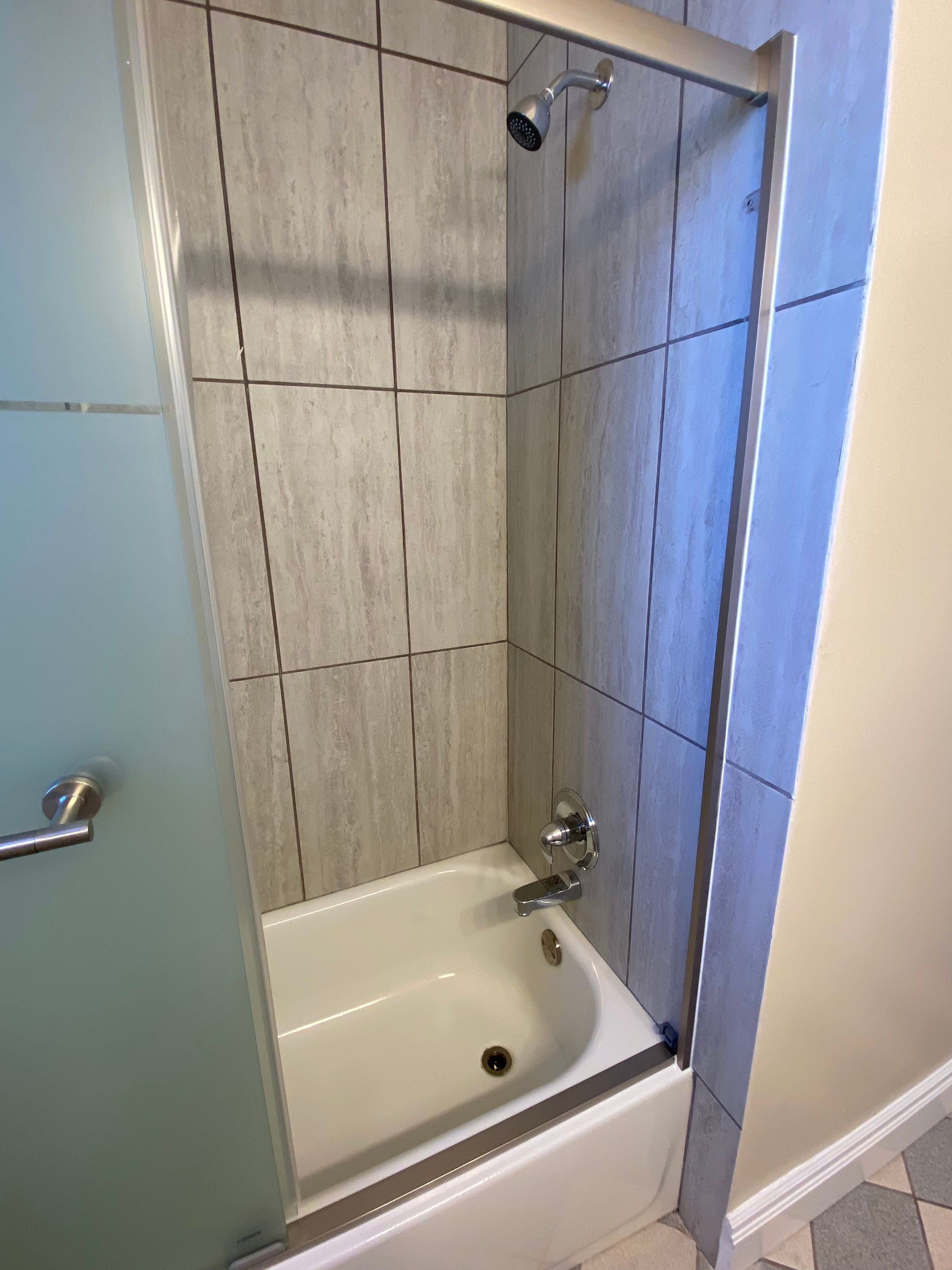 A bathroom with a bathtub and a shower stall.