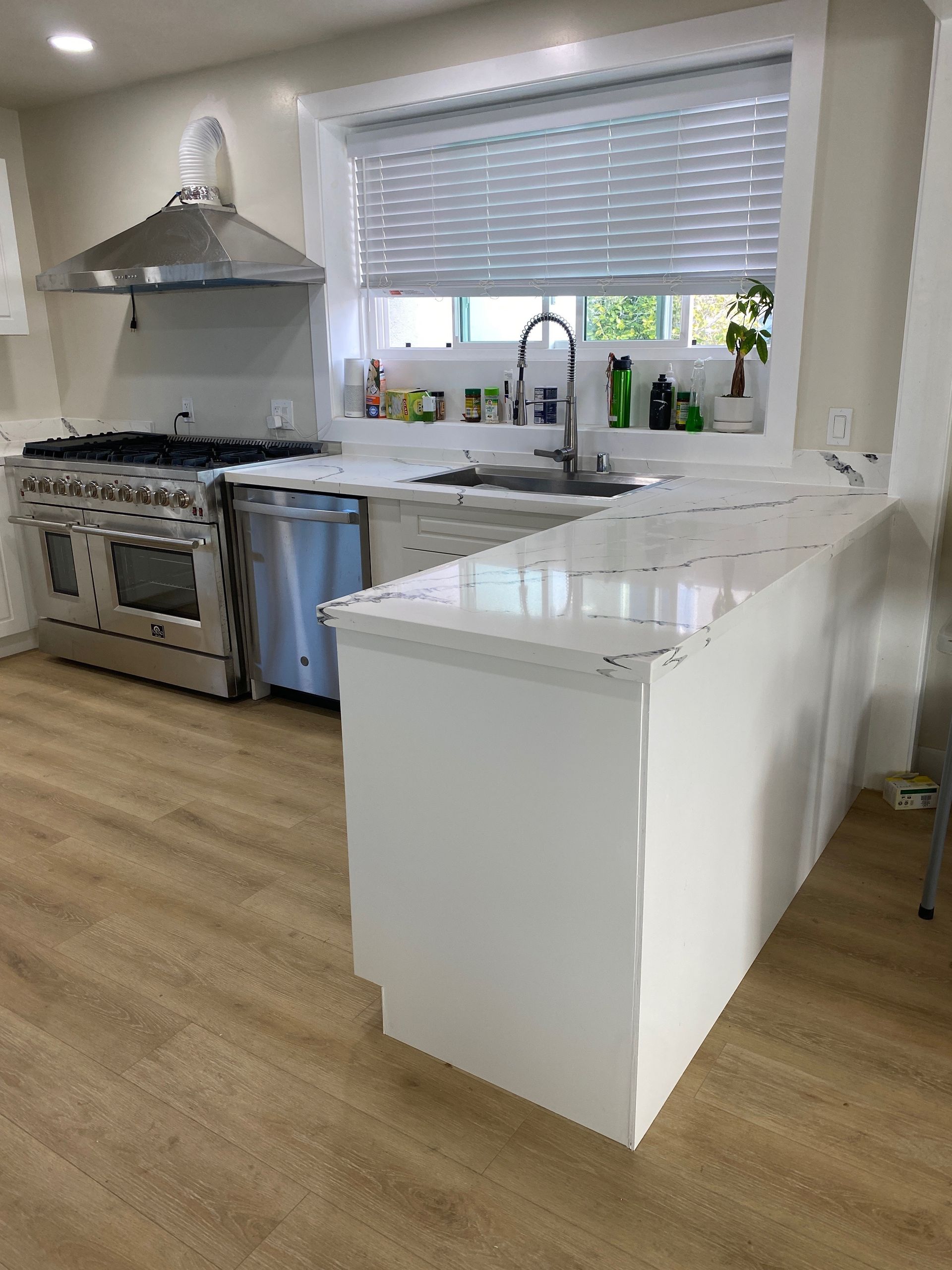 A kitchen with a large island , stove and sink