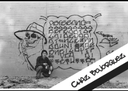 A black and white photo of a man kneeling in front of a wall with graffiti on it