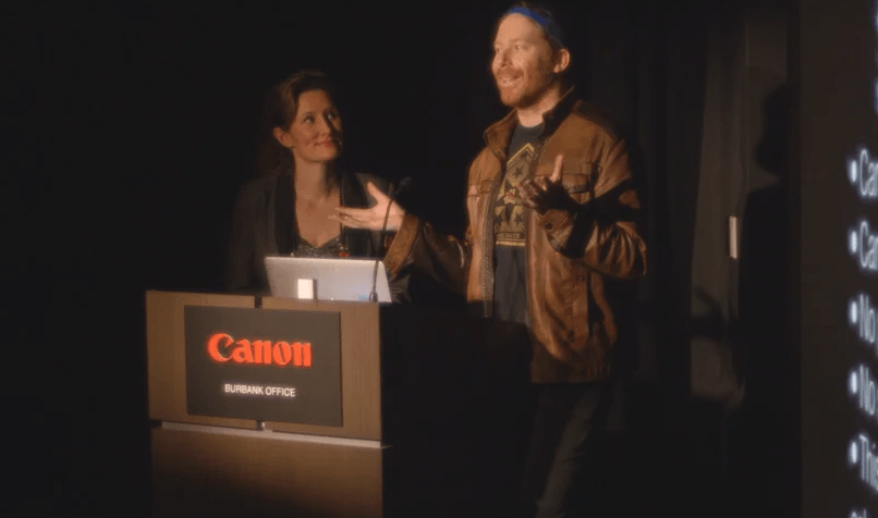 A man is giving a presentation at a canon podium