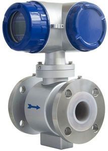 Medidor de flujo electromagnético plateado y azul con bridas y pantalla. Una flecha azul indica la dirección del flujo.