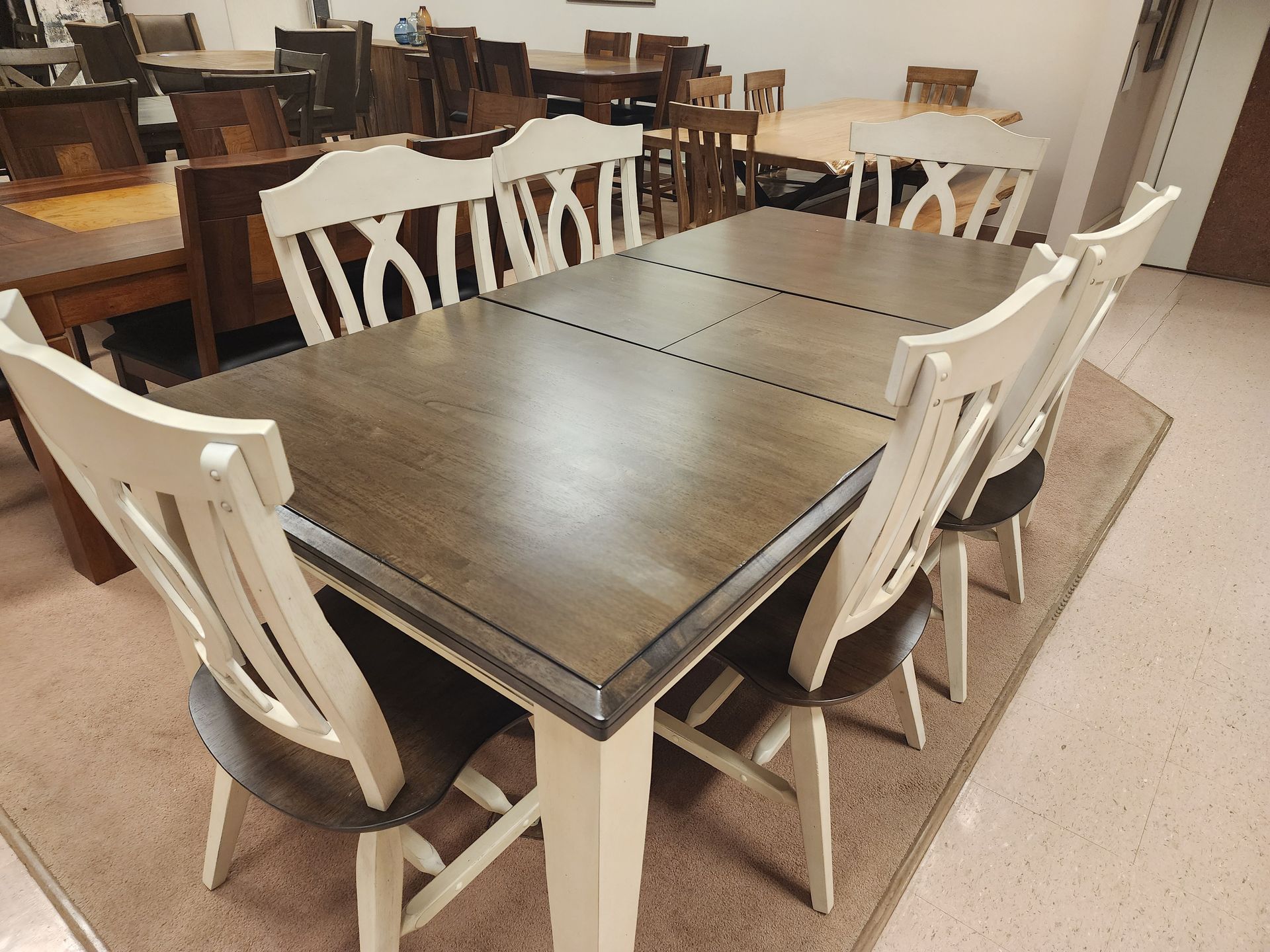 A table and chairs in a room with a rug