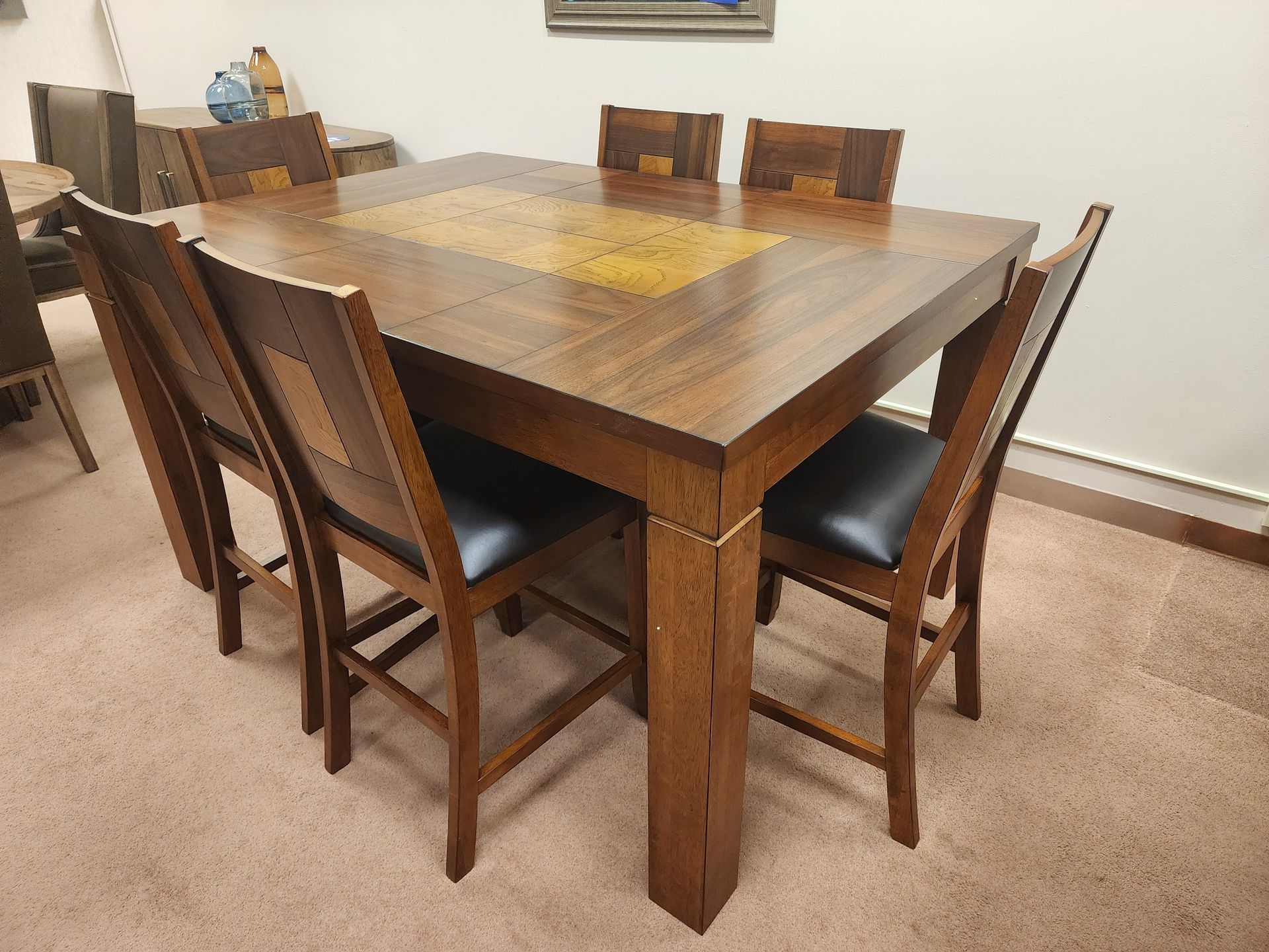 A wooden dining table with four chairs in a room