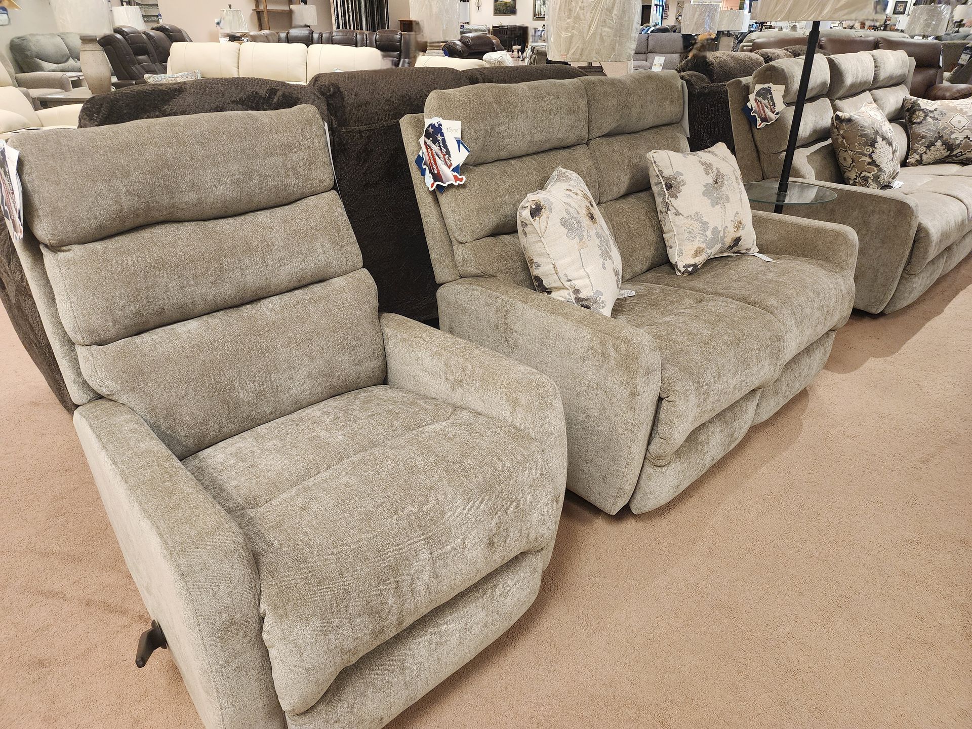 A row of recliner chairs and a couch in a furniture store.