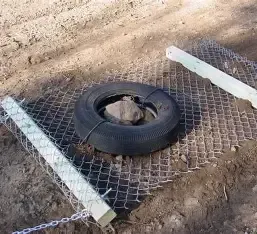 Homeowner dragging a gravel driveway with a lawn tractor to level the surface