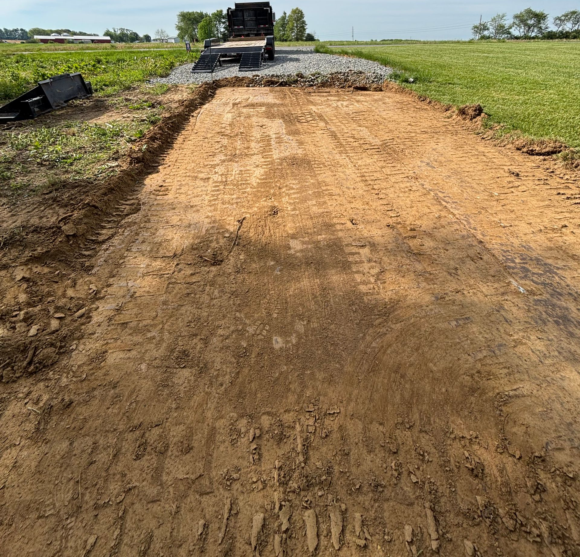 Dump truck and compact track loader installing a construction driveway in Hillsboro, Ohio.