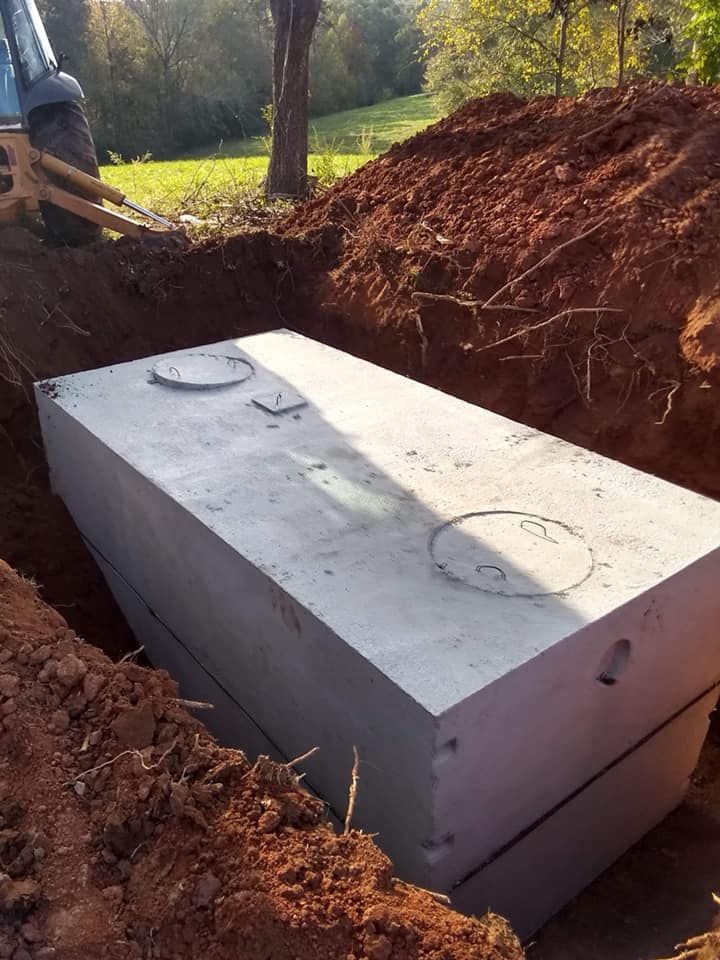 Concrete septic tank in a trench, ready for burial.