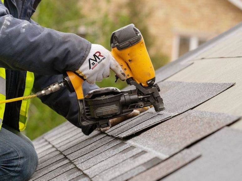 A roofer installing new roof shingles.