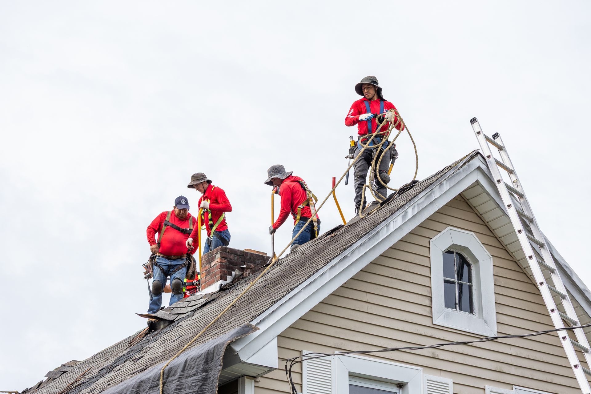 A group of men are working on the roof of a house.