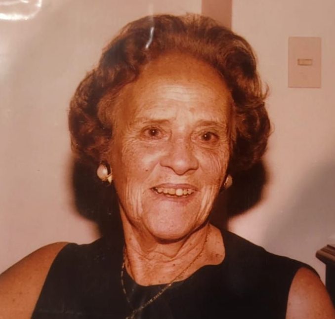 Un primer plano de una mujer que lleva una chaqueta azul y sonríe.