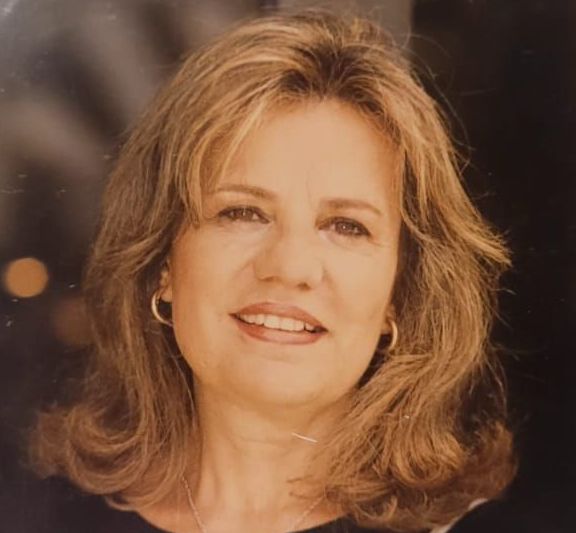 Un primer plano de una mujer que lleva una bufanda y sonríe.