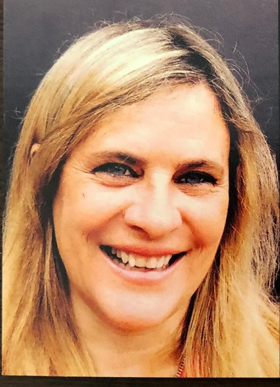 Una mujer con cabello rubio está sonriendo para la cámara.