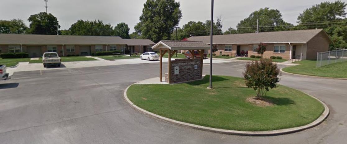 There is a roundabout in the middle of the street in front of a building.