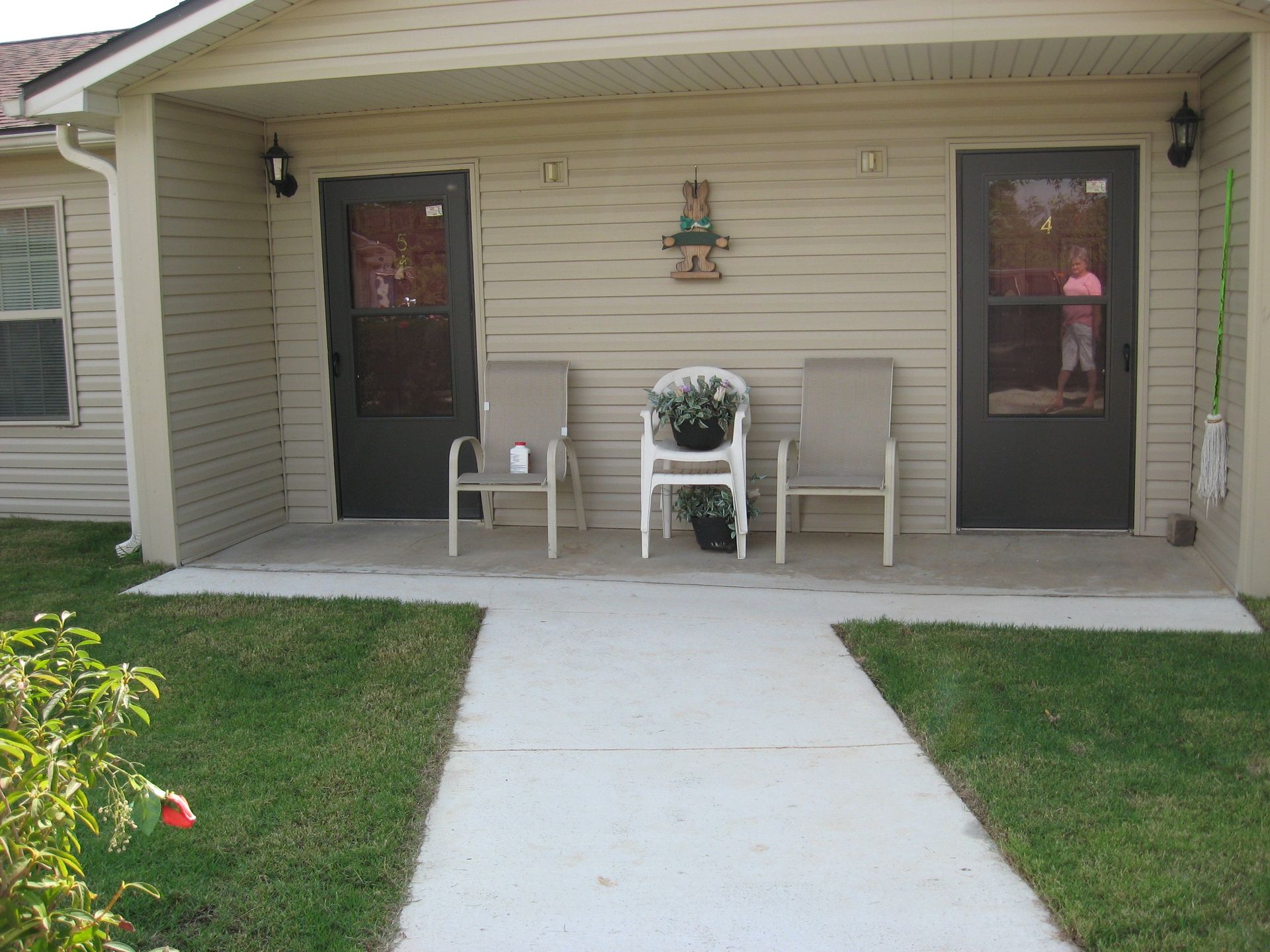 A house with a porch with two chairs and a table