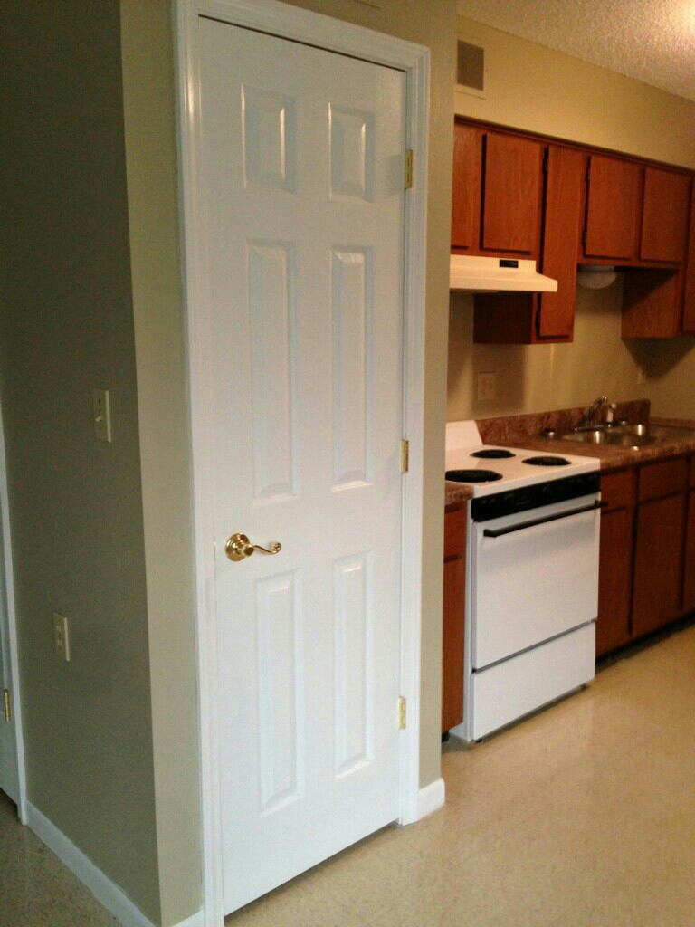 A kitchen with wooden cabinets and a white stove