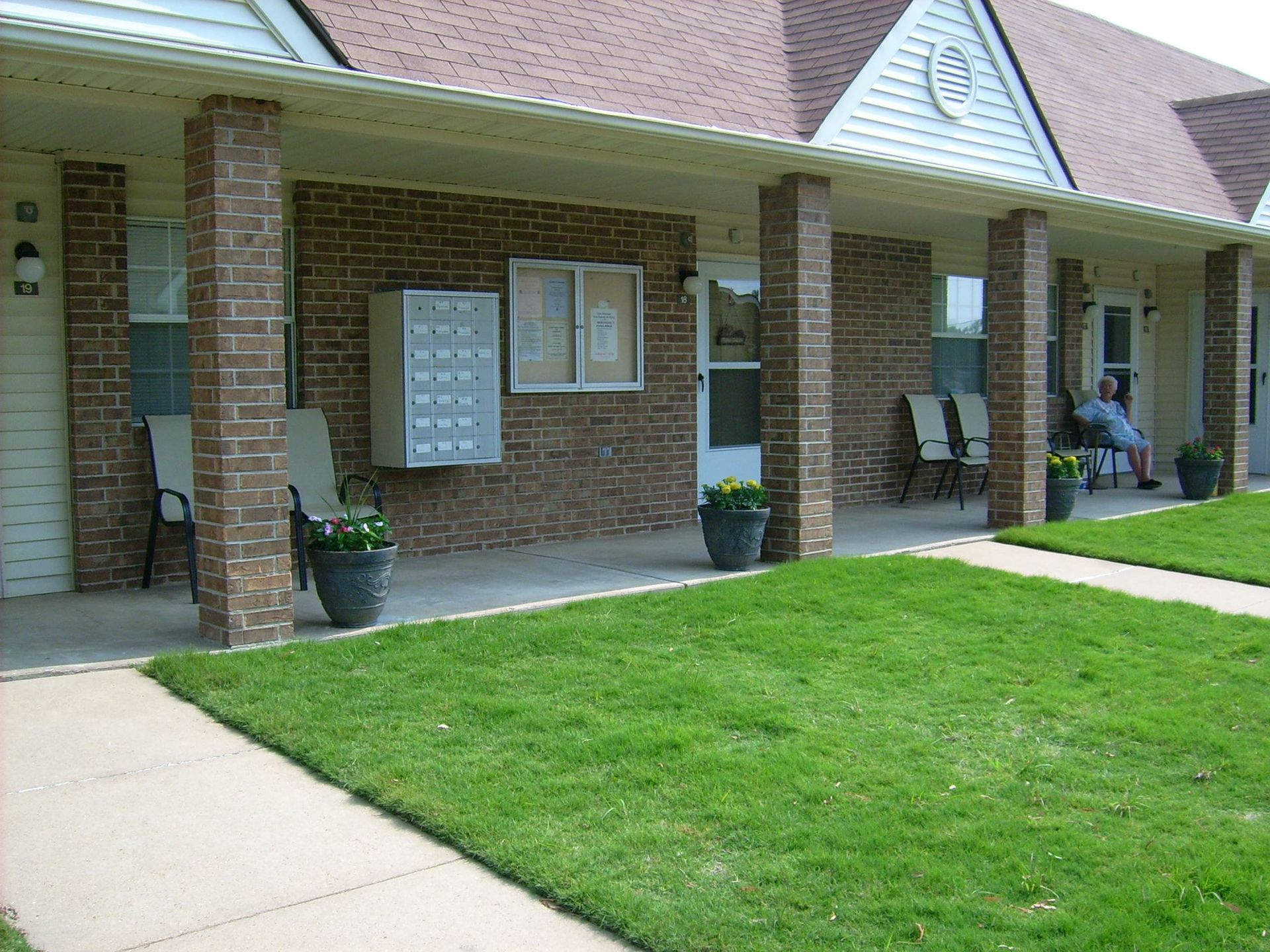 A brick building with a large lawn in front of it