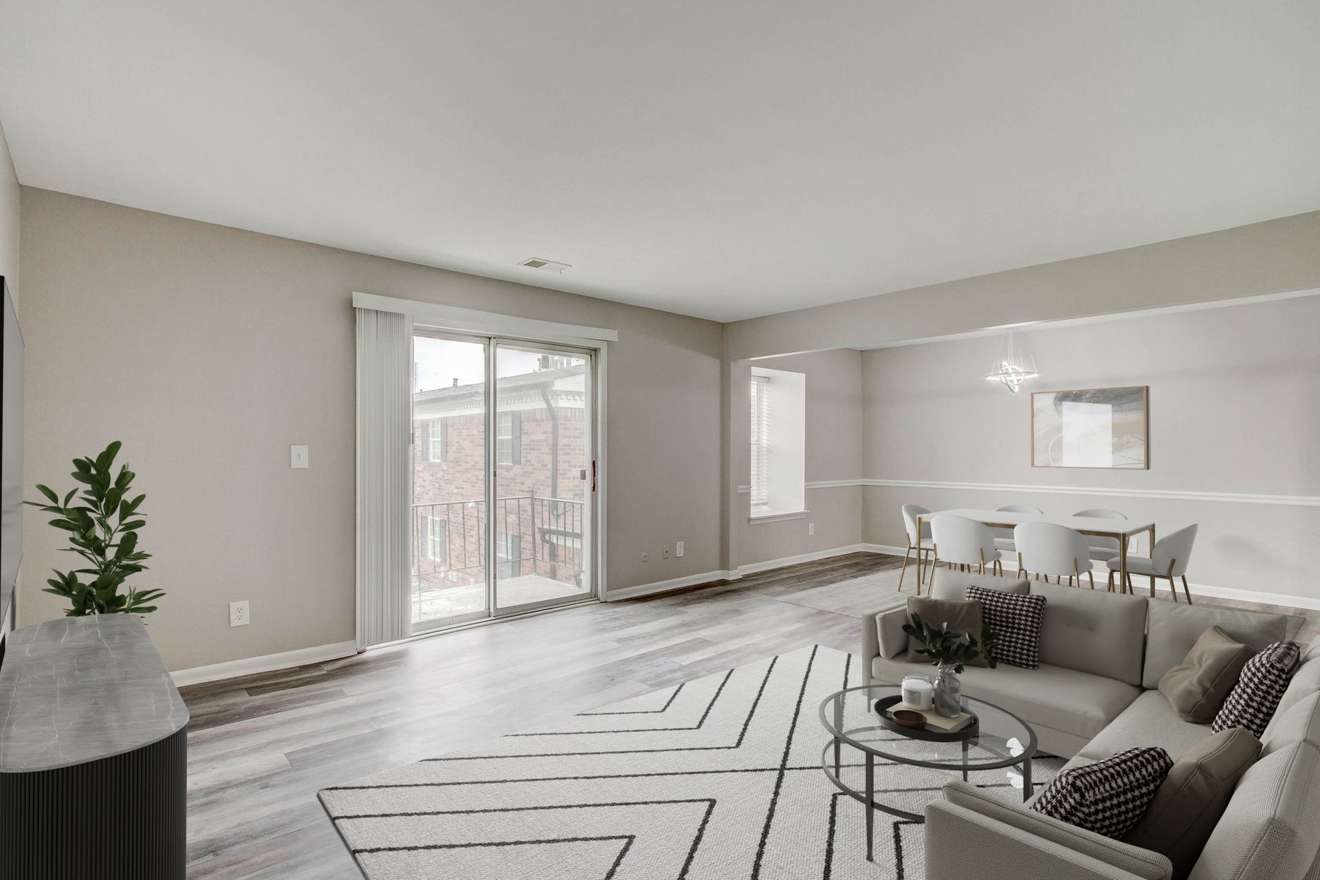 Spacious living room with a sectional sofa, dining area, and sliding door leading to a balcony.
