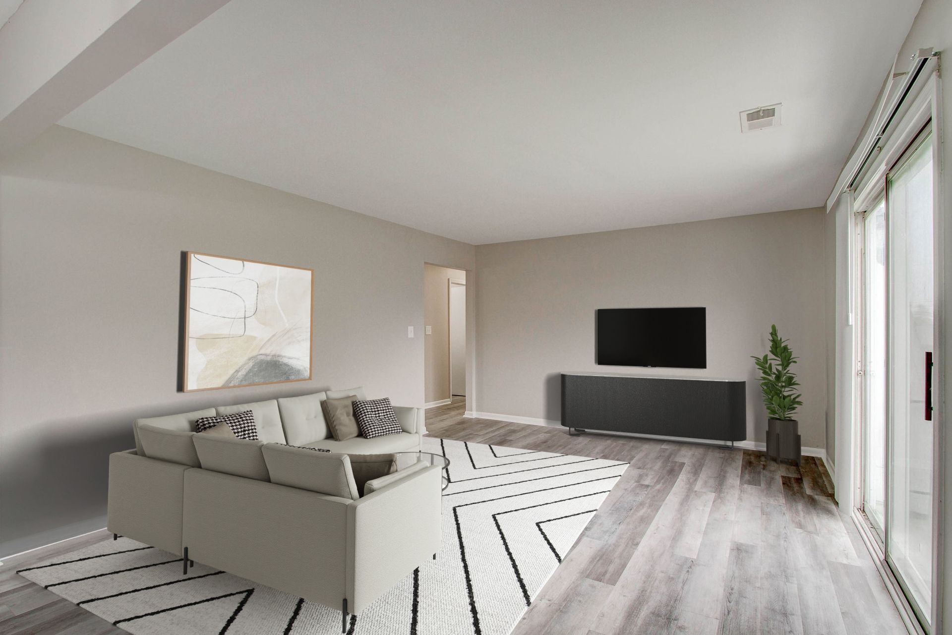 Modern living room with gray walls, sofa, rug, TV, and sliding glass door.