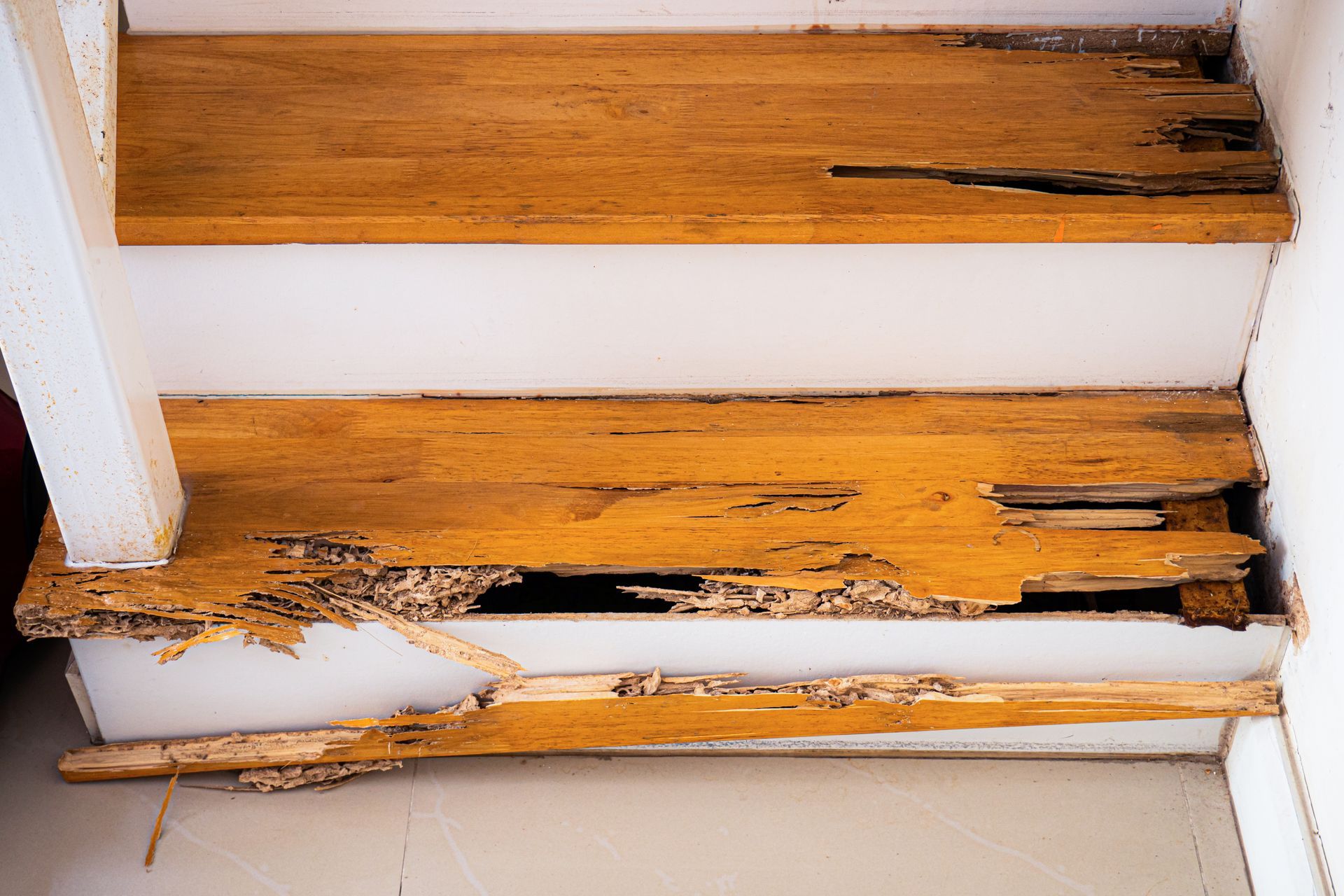 A close-up of wooden stairs that were bitten and destroyed by termites.