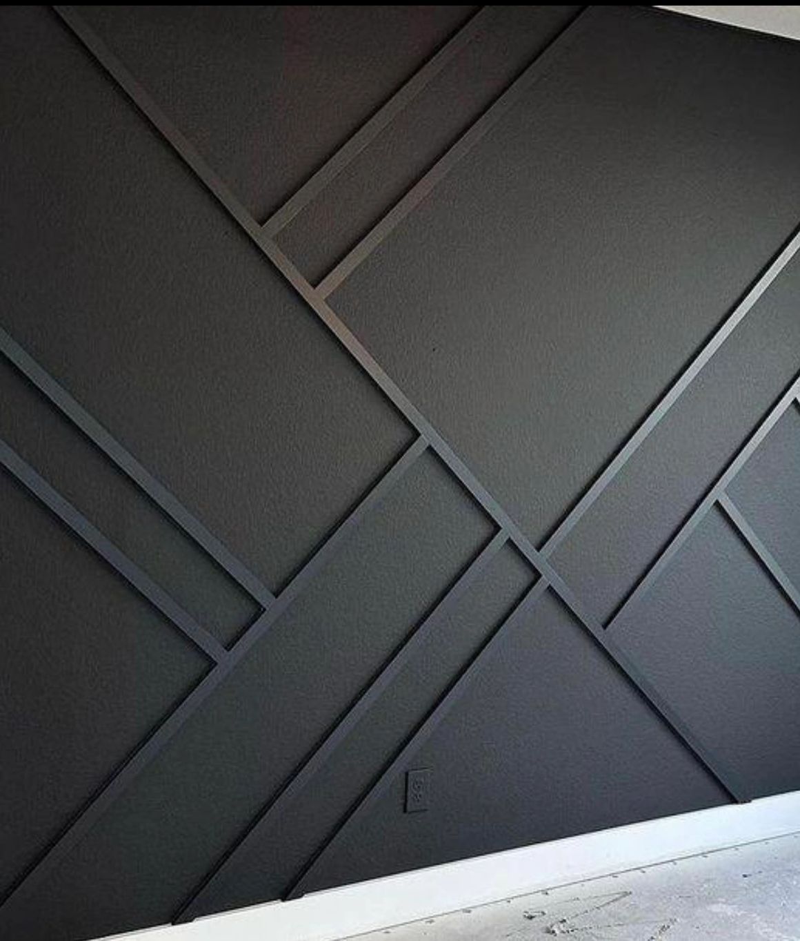 Black geometric wall paneling with a modern design.
