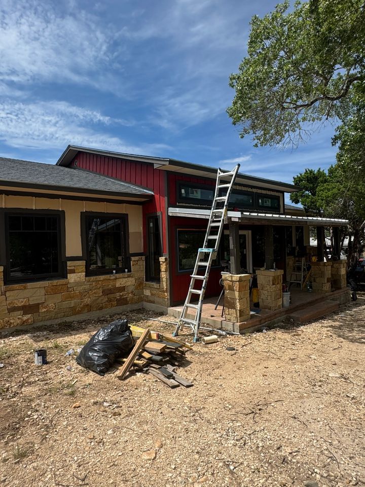 House exterior with red and tan siding; ladder against the side.