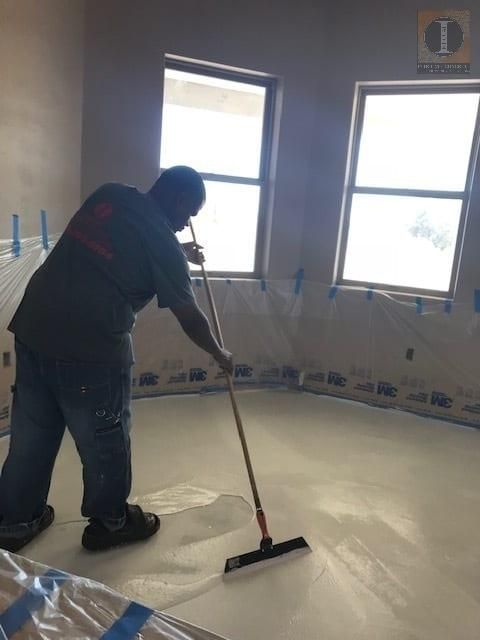 A man is using a broom on a white floor