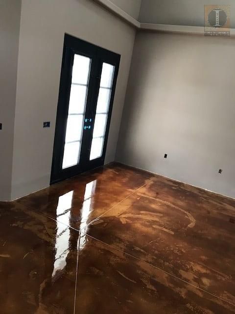 A room with a brown floor and a black door