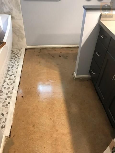 A bathroom with a wooden floor and a bathtub