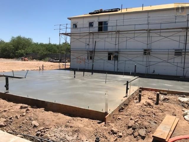 A concrete floor is being built in front of a building under construction.