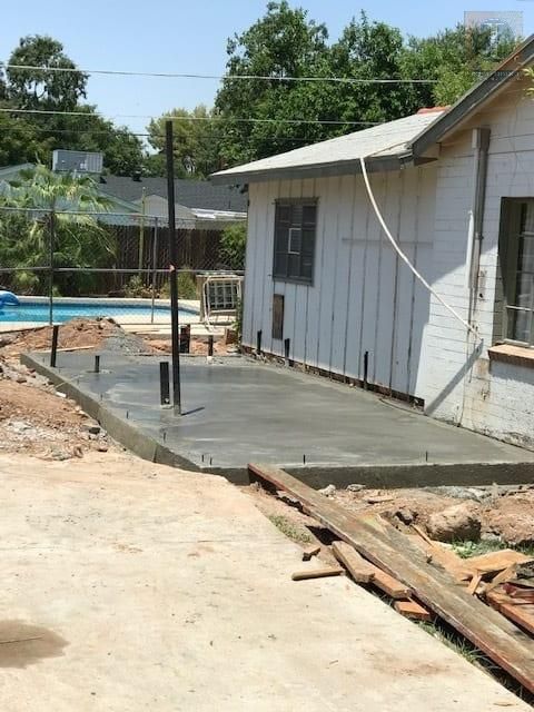 A white house with a concrete driveway in front of it