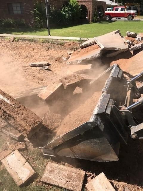 A red truck is parked in the background of a construction site