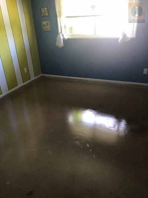 A room with a lot of water on the floor and a window.