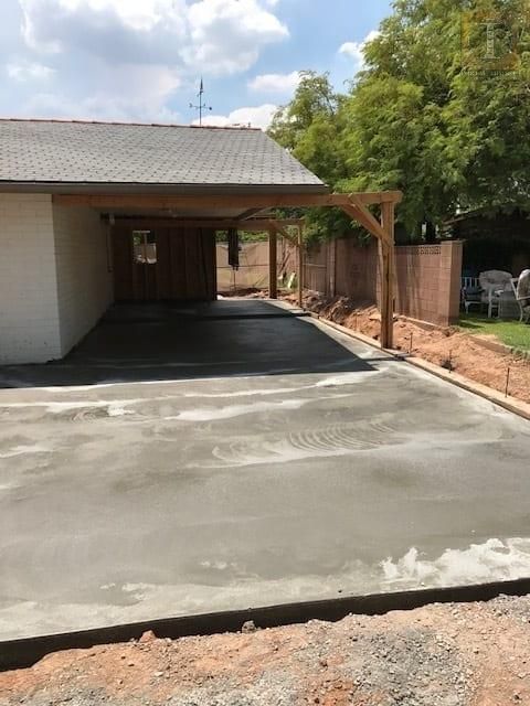 A concrete driveway is being built in front of a house.