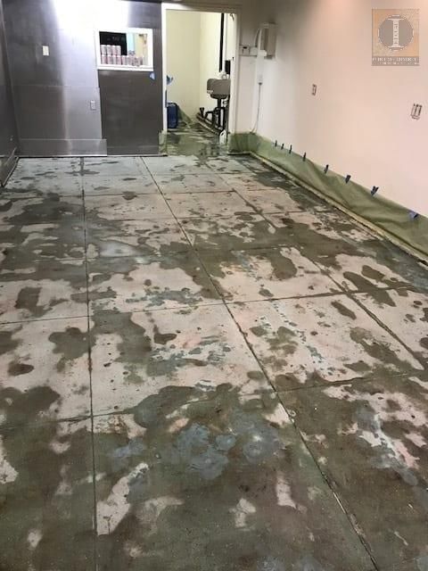 A room with a dirty floor and a sink in it