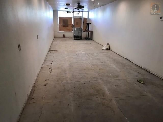 An empty room with a ceiling fan and a few boxes on the floor