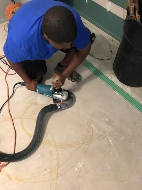 A man in a blue shirt is using a machine on the floor